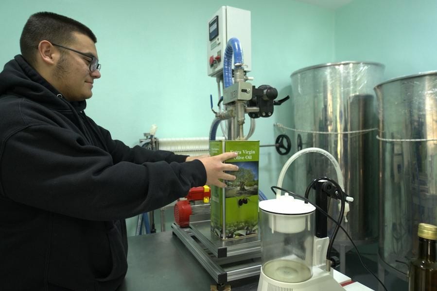Man working on olive oil bottle filling machine at Yennima Yis plant
