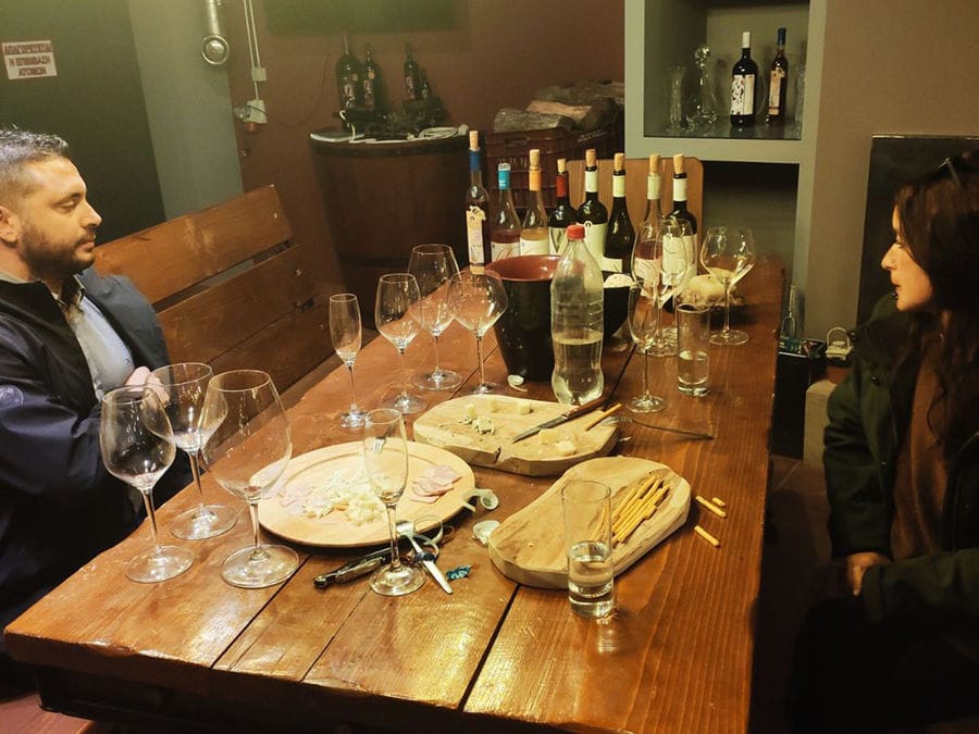 Two people tasting wine at a bright and modern table. They examine the color and savor the taste in a sophisticated yet welcoming atmosphere.