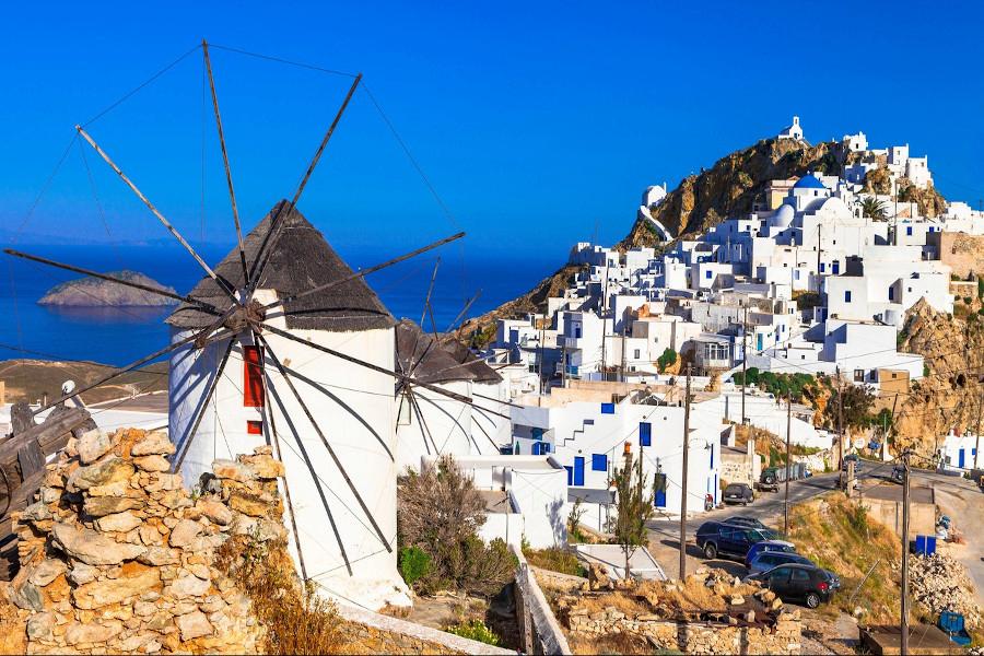 millhouse at Serifos and white buildings on the mountain and the sea in the background