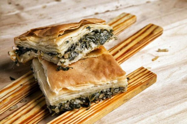 two pieces of ‘Hortopita’ is a combination of spinach and feta cheese tucked in layers of filo dough on the top of each others