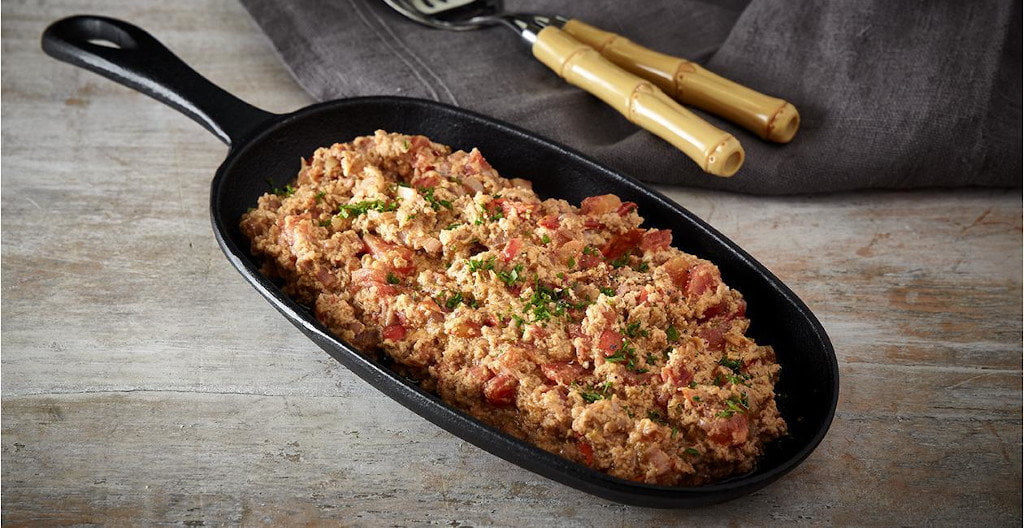 Greek Strapatsada mixing from tomatoes with eggs and feta cheese beaten together and baked in a pan