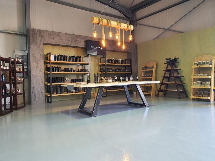 Tasting room with table with and shelves on the walls with bottles with products of olive oil Oilympian Koufolias