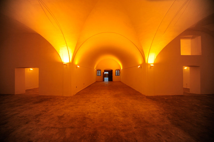 empty illuminated room and corridor with arches at 'Tomato Industrial Museum'