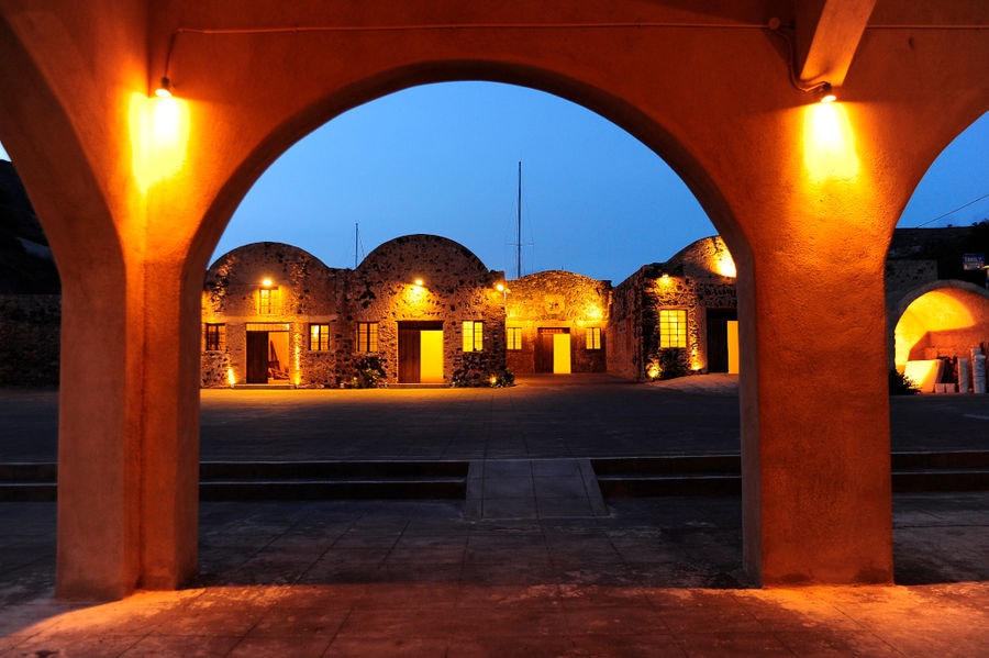 illuminated building of 'Tomato Industrial Museum' through an outdoor arch