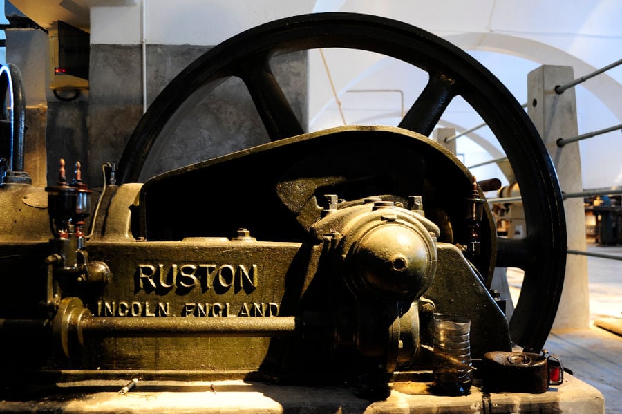 metal wheel, part of an old machine that says 'RUSTON' at 'Tomato Industrial Museum'