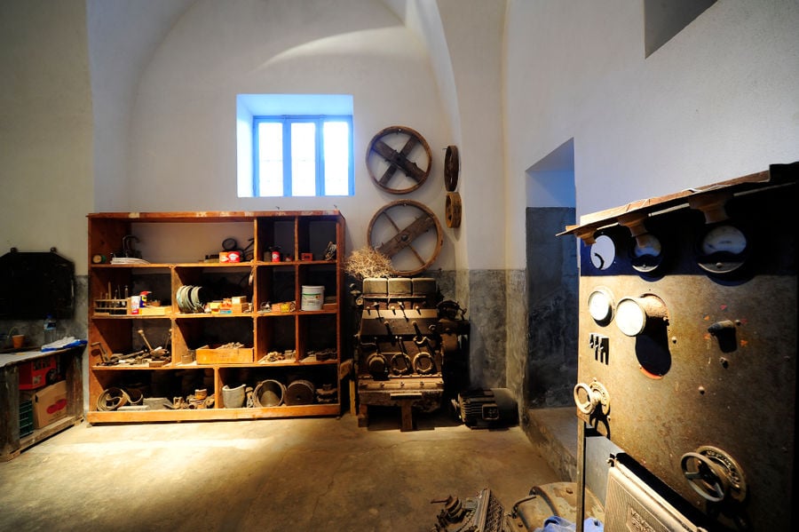 old tomato paste processing equipment and wooden shelves with tools at 'Tomato Industrial Museum'