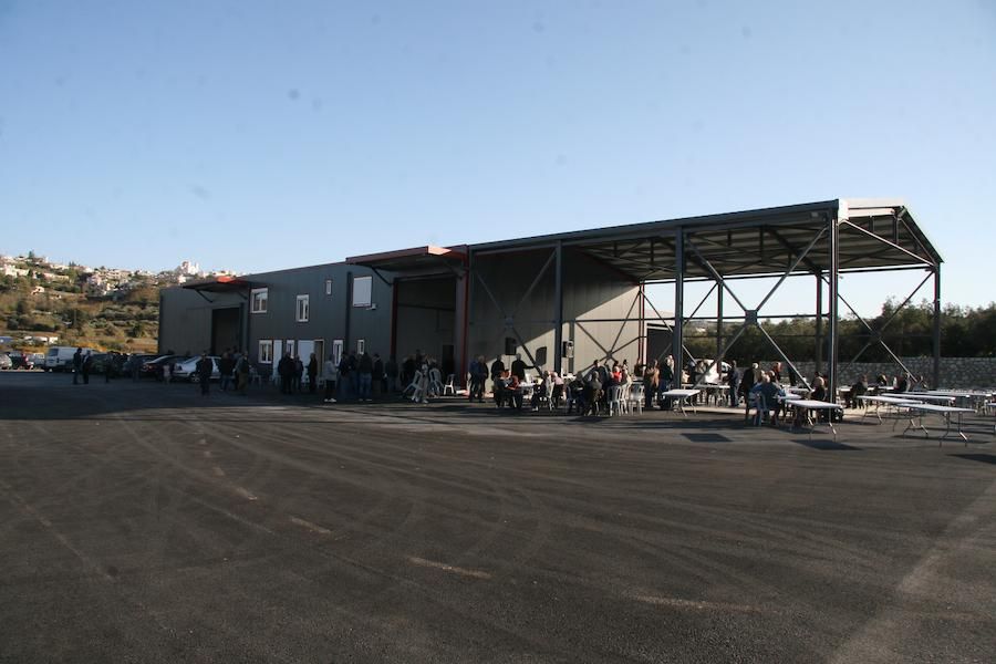 Tourists outside at Politakis Olive Oil Mill industrial building surrounded by pavement