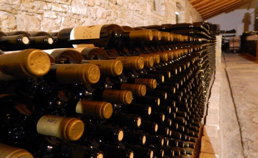 stacked wine bottles on top of each other on the wall of 'Theotoky Estate' cellar