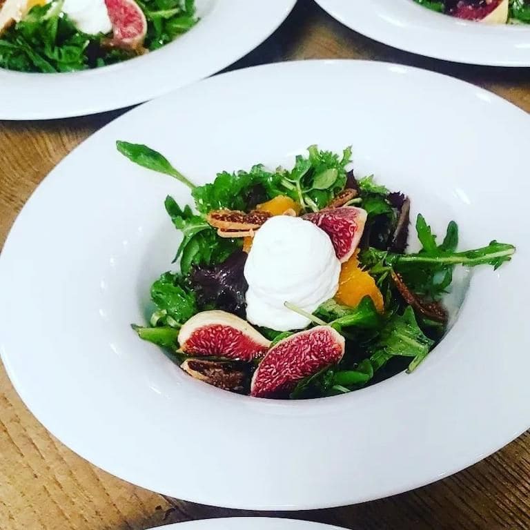 close-up of a plate with salad, pieces of fresh figs and a spoon of yogurt at Savor Nafplio