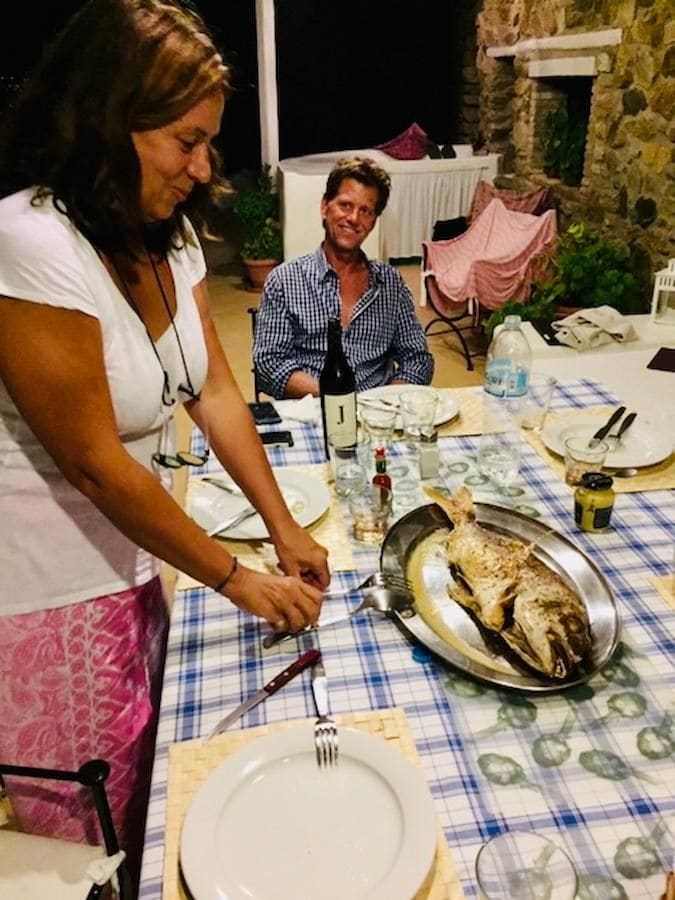 a woman is serving roasted fish and a man is shouting at her from Greek Cooking Class from Two Minutes Angie