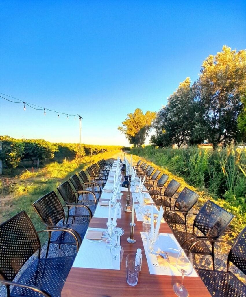 A large table set for wine tasting with glasses and candles