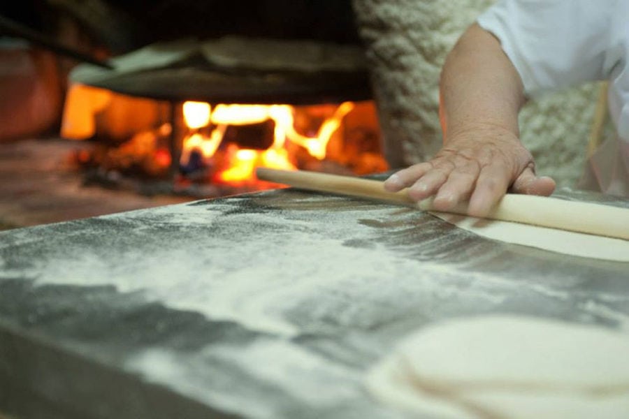 women using wood dough paddles to make pies at 'Agios Antonios Women’s Agri Cooperative' workshop