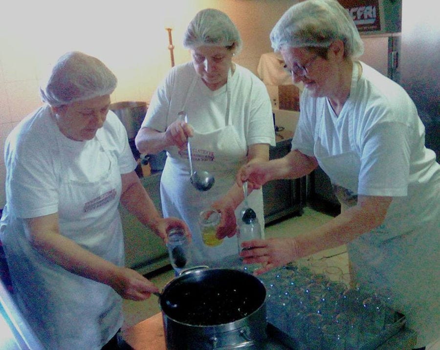 women filling jars with marmalade with ladles at 'Agios Antonios Women’s Agri Cooperative' plant