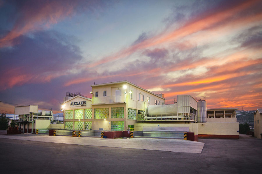 front view of the building that says "ALEXAKIS WINERY' on the wall in the background of sunset