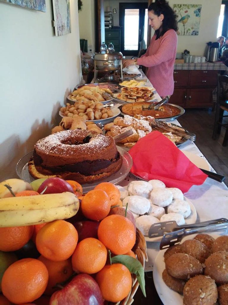 woman cooking on the table with a lot of sweets like pies and cakes at Amfikaia kitchen