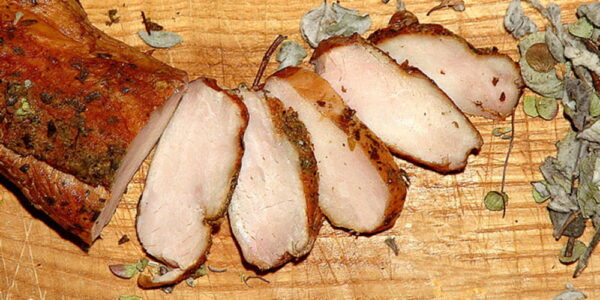 Close-up of slices of Greek apaki like ham on wood surface