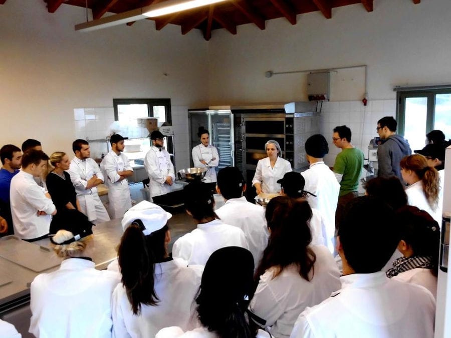 The tour guide explains to visitors the bread making process in the internal preparation room