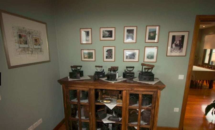 Furniture with old irons and frames with photographs on the walls