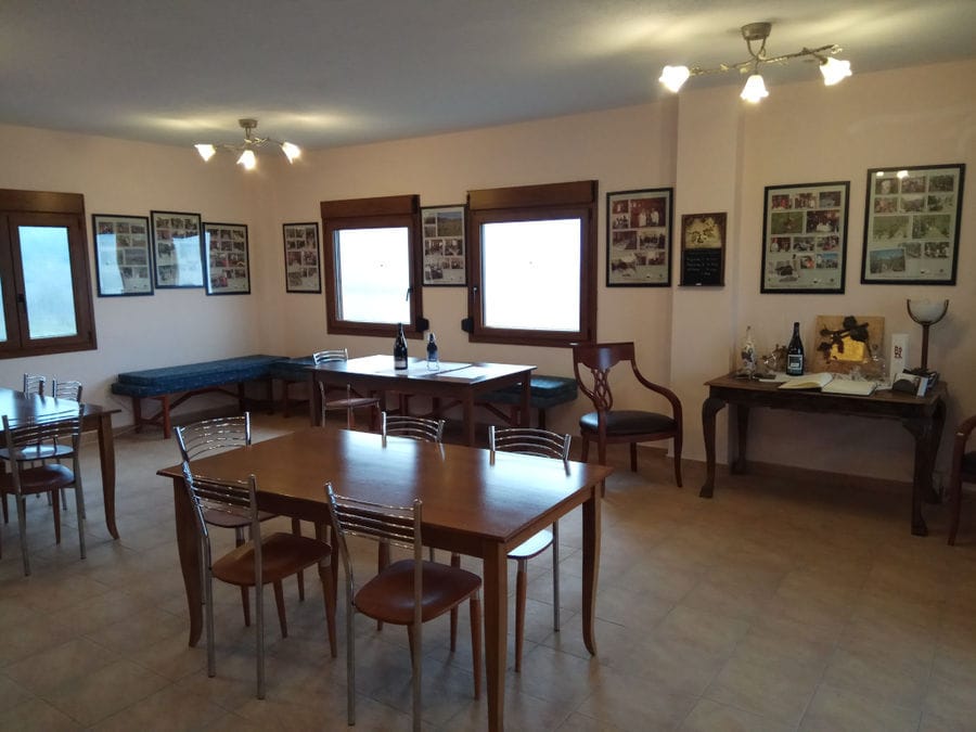 'Argatia Winery' room with wood tables and chairs and frame carts on the wall