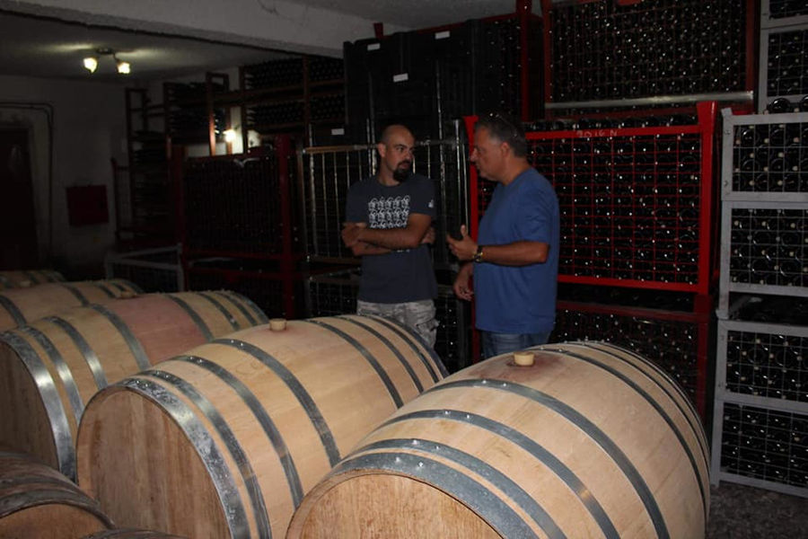a tourist listening to a guide at 'Argatia Winery' cellar