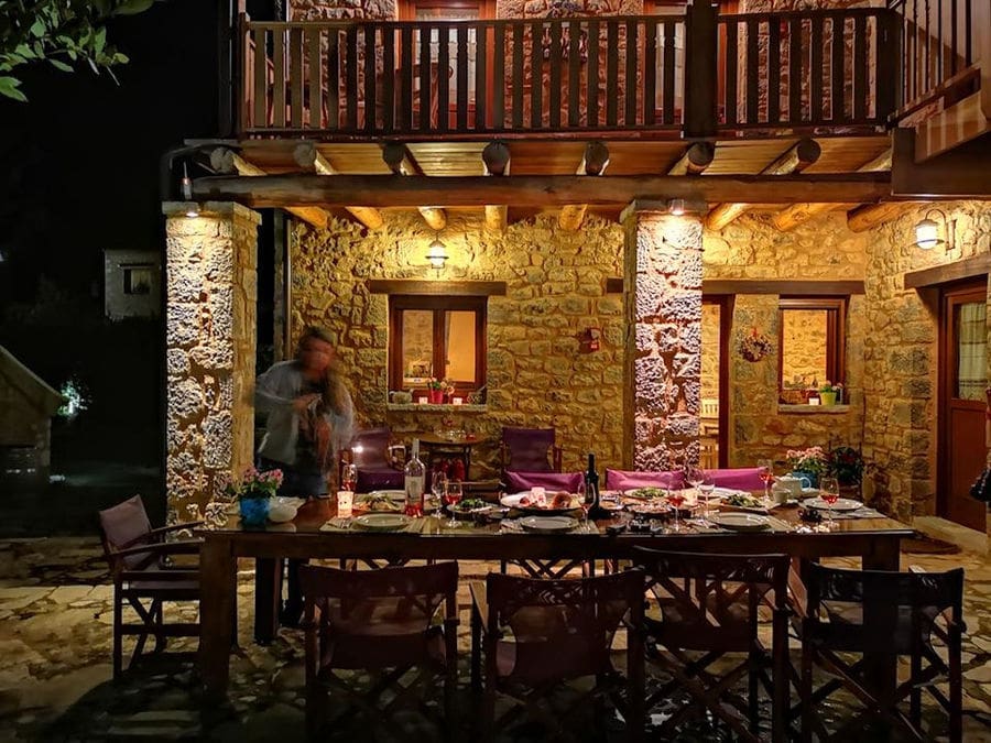 woman arranging a tasting table with food at Argyriou Winery outside by night
