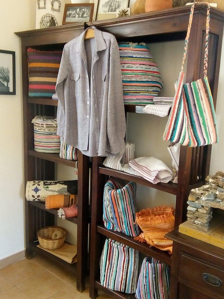 handmade colourful cloth baskets, bags and pillows on wooden shelves at Aristaios' folklore museum