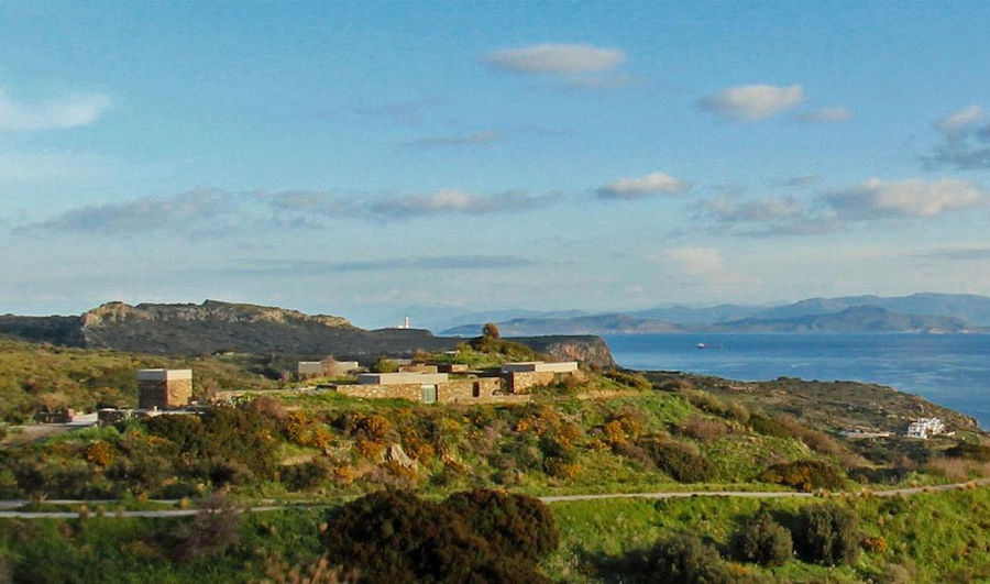 far view of 'Astarti' complex buildings surrounded by trees and the sea in the background