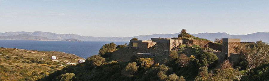 far view of 'Astarti' complex buildings surrounded by trees and the sea in the background