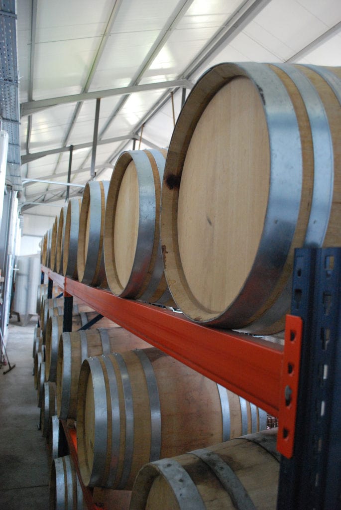 lying wine wood barrels on top of each other at 'Belidis Vineyards' cellar