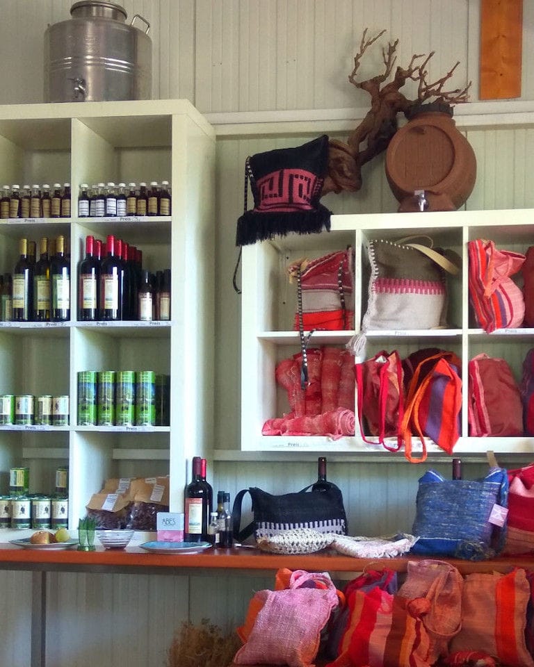 wine bottles, bags on the wooden shelves at Bio Goupios