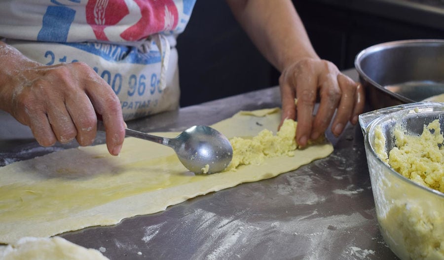 hand hold spoon and put cheese on the phyllo at Bioporos