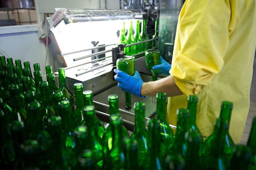 man placing bottles on the machine at Bläuel Greek Organic Products