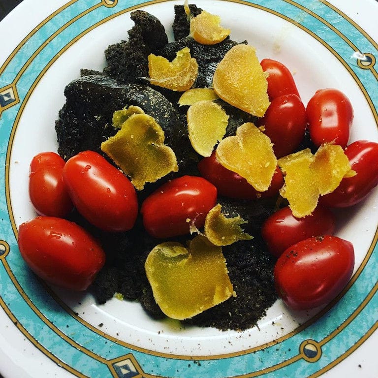 dry slices of avgotaraho with tomatoes and truffles on the plate from Bottarga Stefos