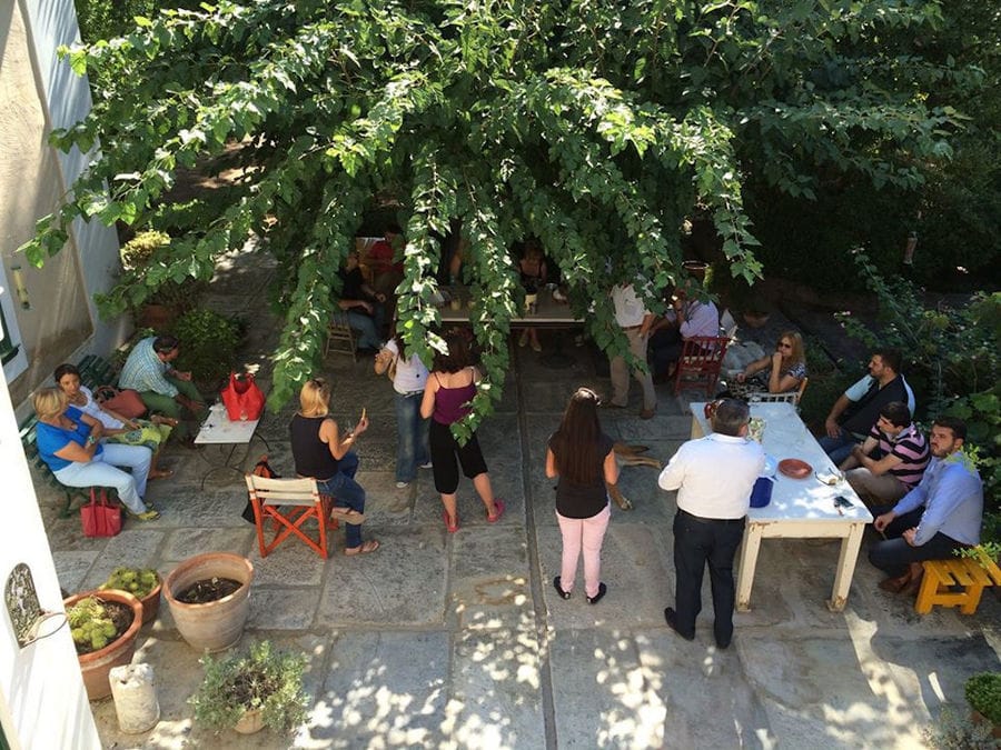 tourists sitting in the shade of the trees at Boutari Santorini Winery