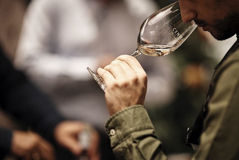 Close-up of a man tasting wine at central wine fair|