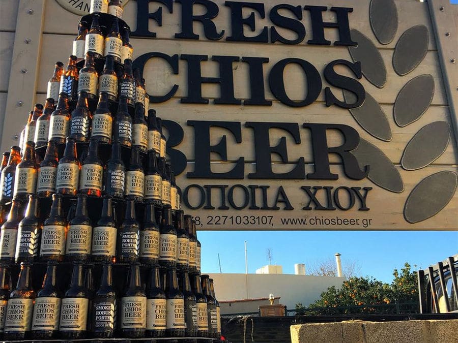 beer bottles on top of each other in front the wood frame that says 'Fresh Chios beer'