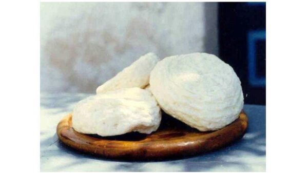 Close-up of round pieces of Greek ‘Chloro’ a fresh cheese with a soft texture on wooden platter