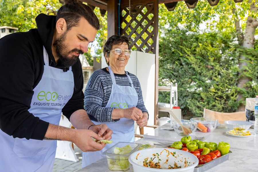 A man and a woman passionately cook Crete's traditional meals, their hands gracefully moving amidst the aromas of local ingredients, bringing to life the essence of Cretan cuisine with every dish they create.