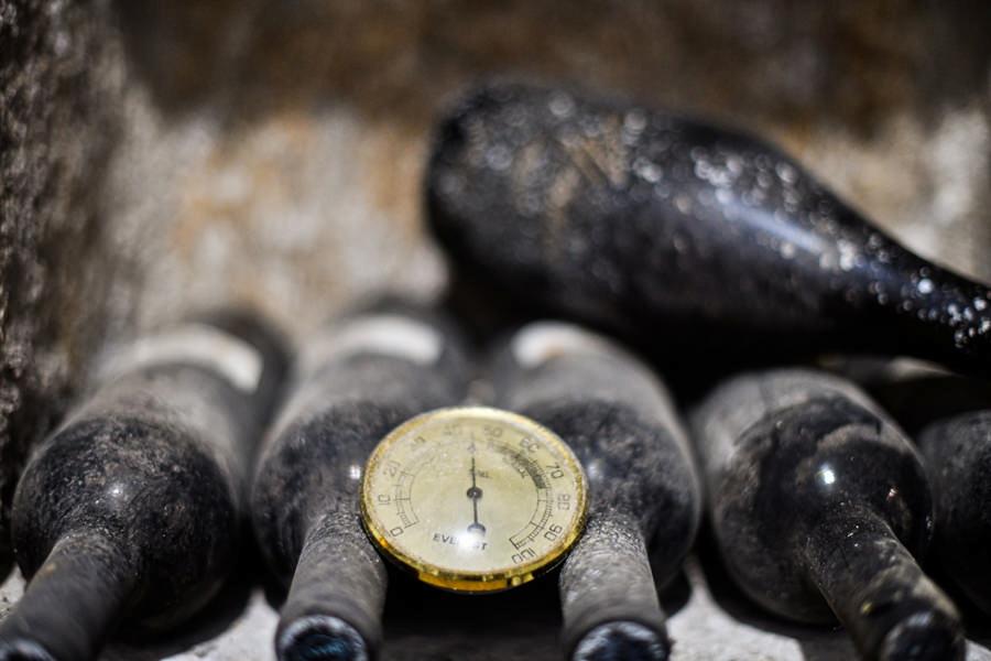 close-up of wine bottles with dust on them placed horizontally and a manometer between them at Afianes wines|