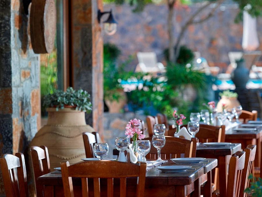 wooden tables with glasses and plates expect the tourists to eat at Country Hotel Velani