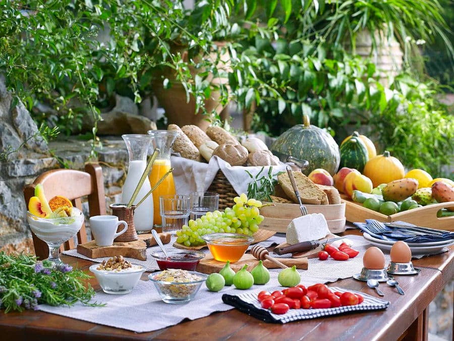 juice, milk, tomatoes, figs, honey, cheese on the wood table at Country Hotel Velani