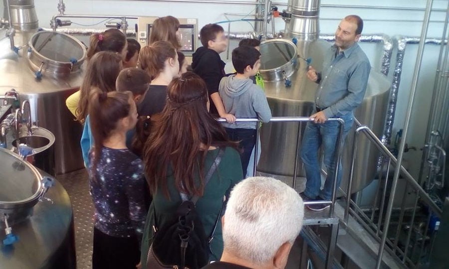 tourists listening to a man giving a tour at Cretan Brewery plant