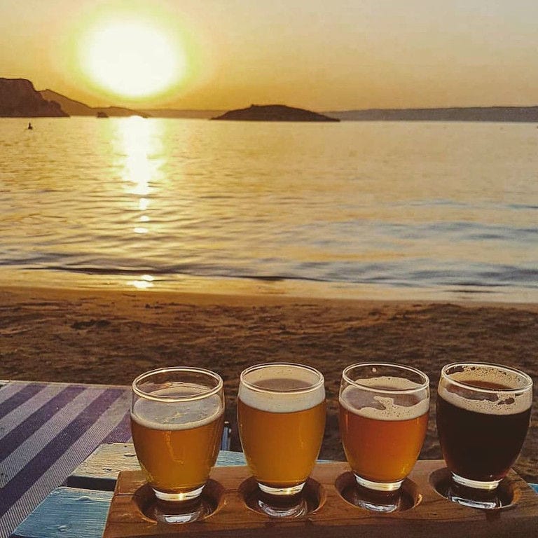 glasses with beer in the background of sea and sunset at Cretan Brewery