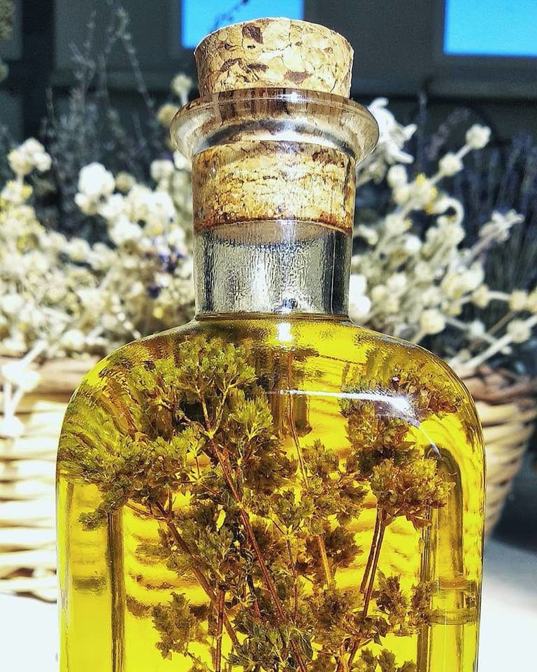 bottle with olive oil and bunch of dried aromatic herbs inside from 'Cretian Feast'