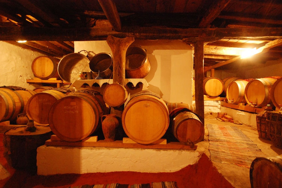 exhibition room with wood ceiling at 'Dio Fili' with old wine barrels and traditional carpets