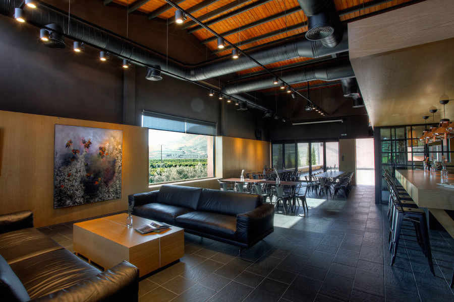 wine tasting room with tables, chairs and leather couches of 'Domaine Skouras' winery