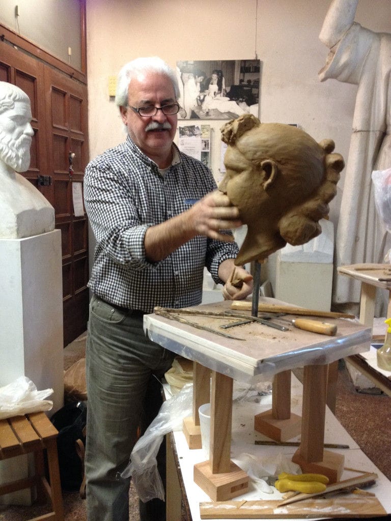 sculptor man modeling a plaster bust at 'Domaine Anagennisi' workshop