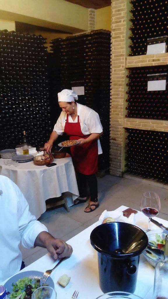 woman chef serving the tourists with delicacies and wine at 'Domaine Anagennisi' cellar