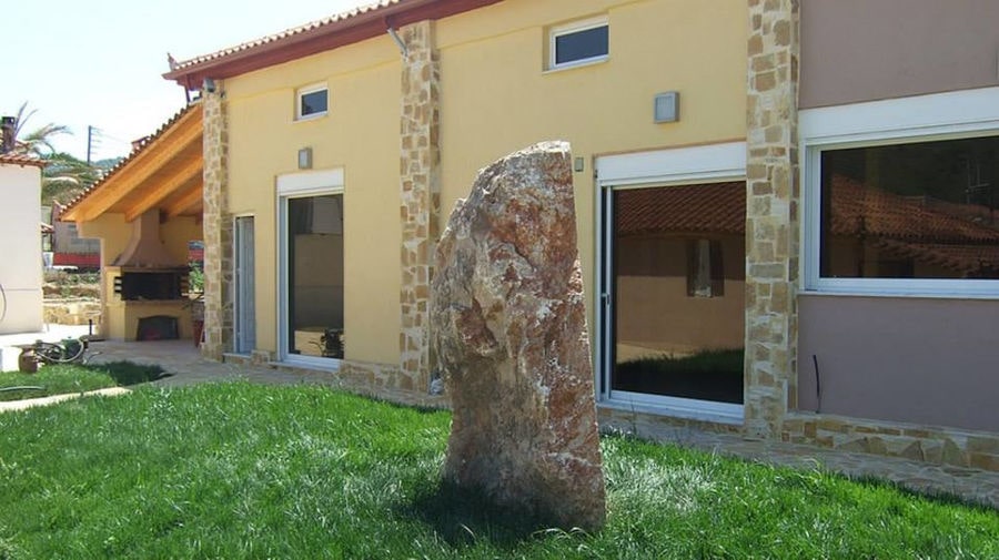 stone sculpture on green lawn in the front of 'Domaine Anagennisi' winery