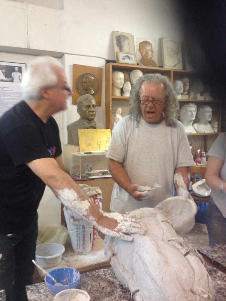 sculptor teaching a tourist how to model plaster in the 'Domaine Anagennisi' workshop